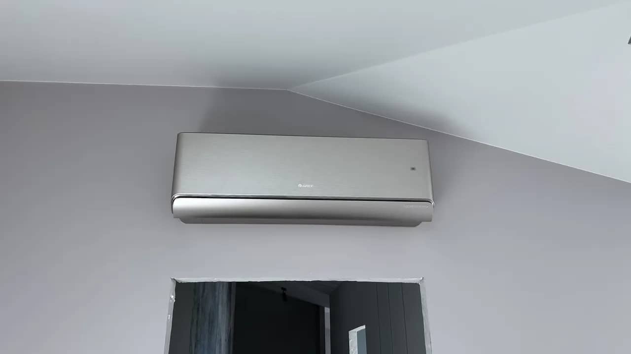 Ścienny klimatyzator Gree zamocowany wysoko pod pochyłym sufitem
