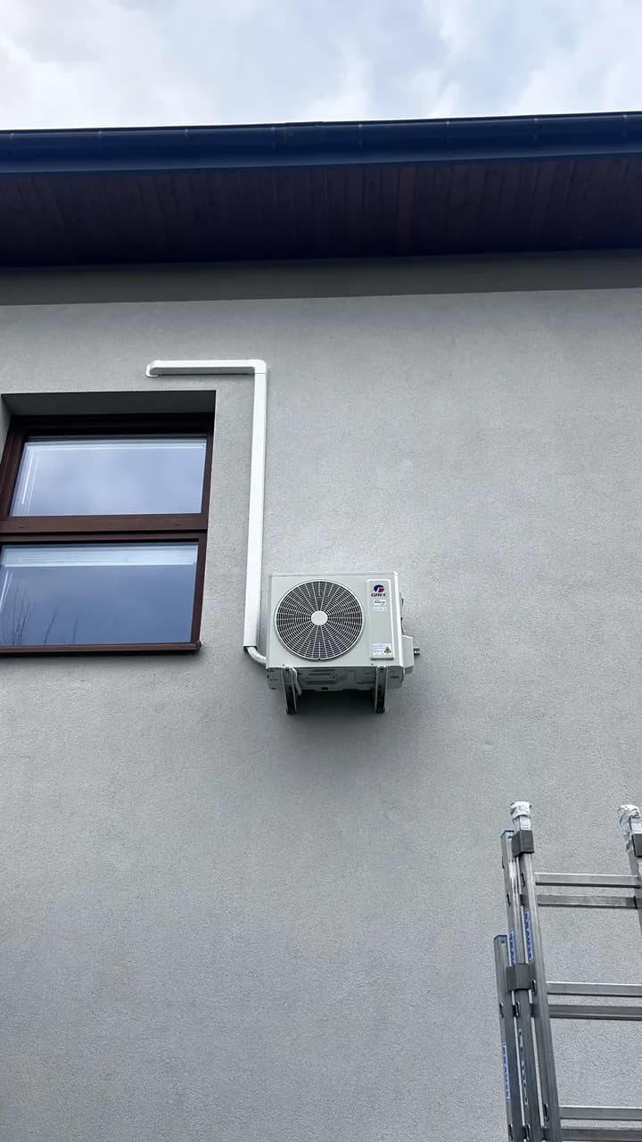 Agregat Gree nad elewacją na stalowych wspornikach obok białego kanału