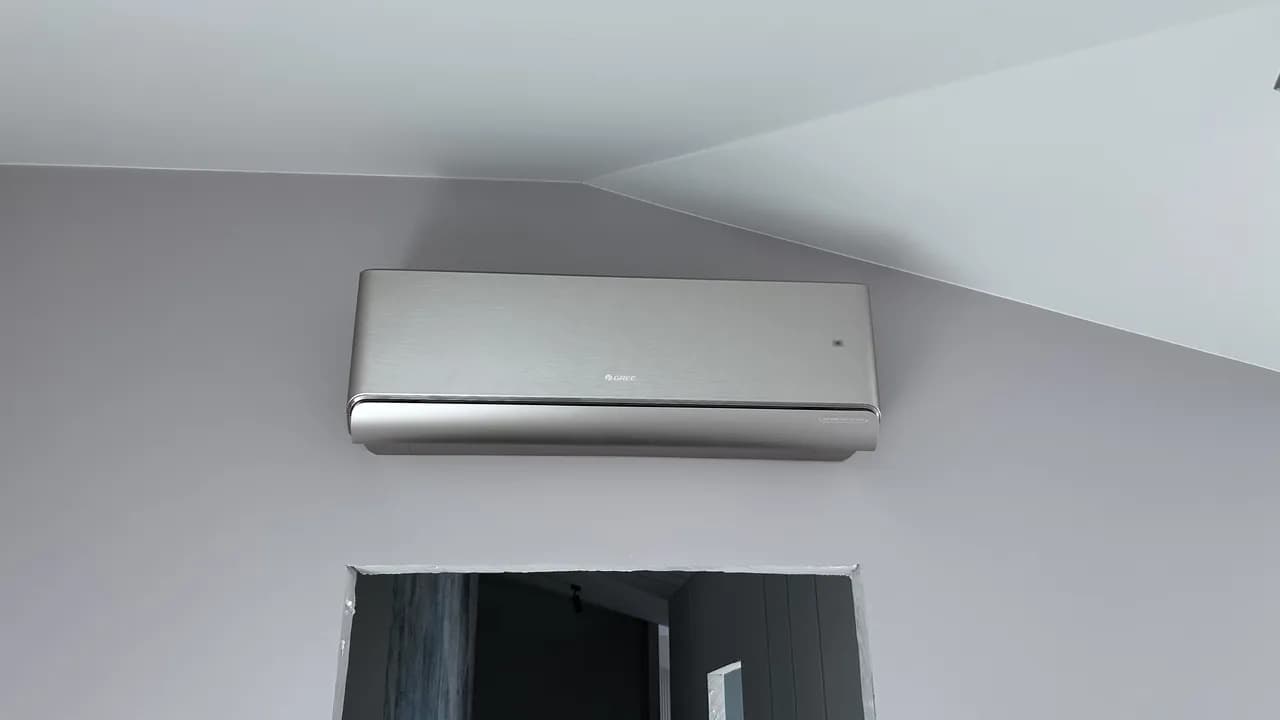 Ścienny klimatyzator Gree zamocowany wysoko pod pochyłym sufitem