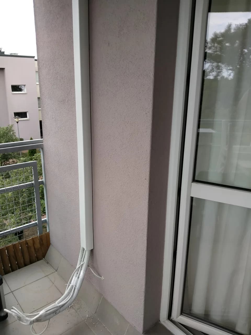 Instalacja klimatyzacji w listwie schodząca po ścianie balkonu wyłożonego płytkami