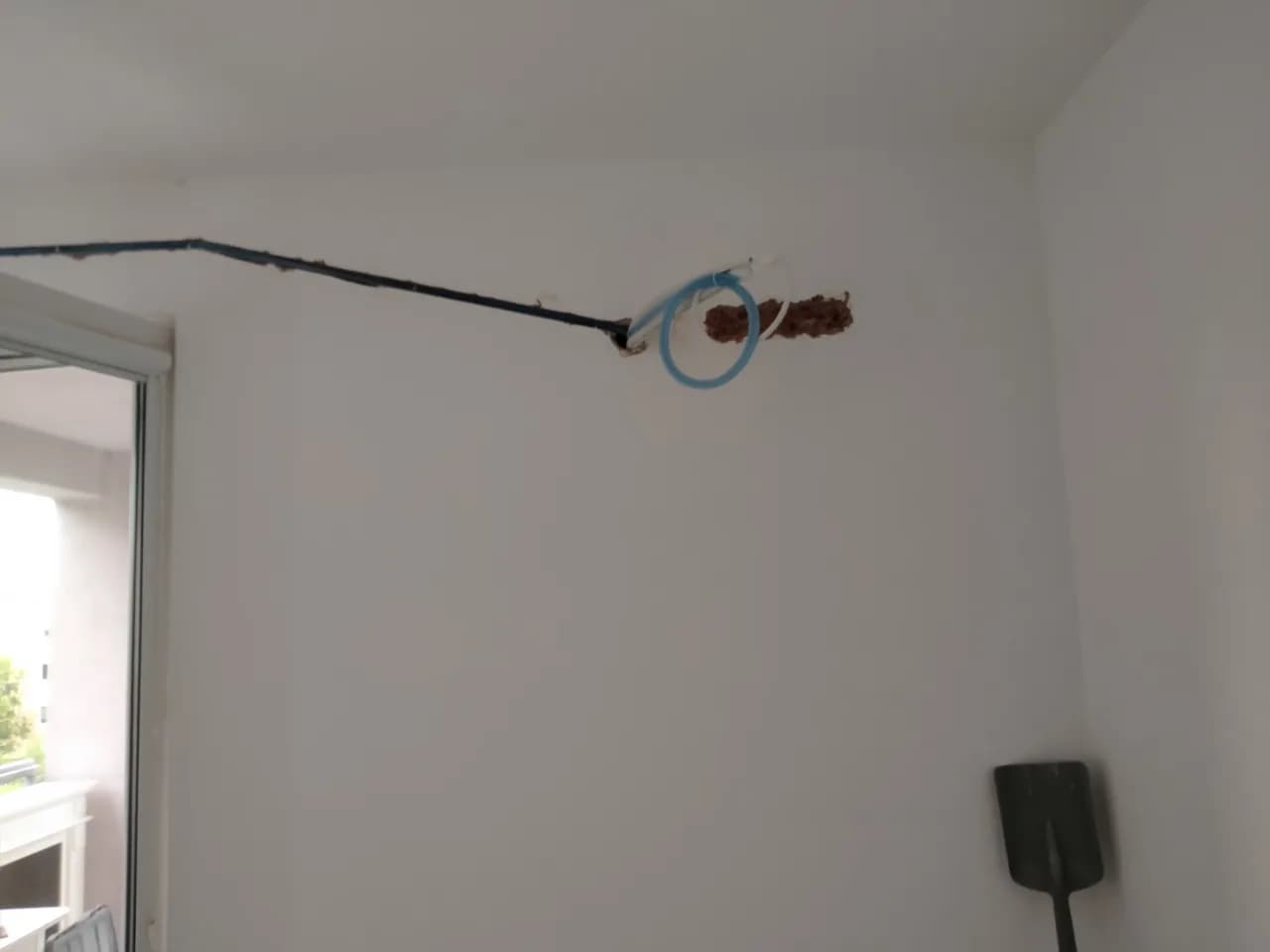 Bruzda w ścianie pokoju z ułożoną rurą chłodniczą i przewodem elektrycznym