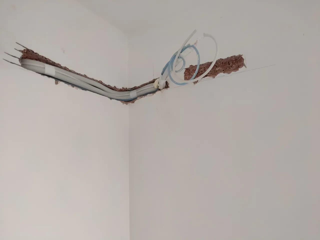 Zbliżenie na instalację chłodniczą i przewód elektryczny ułożone w bruździe ściennej