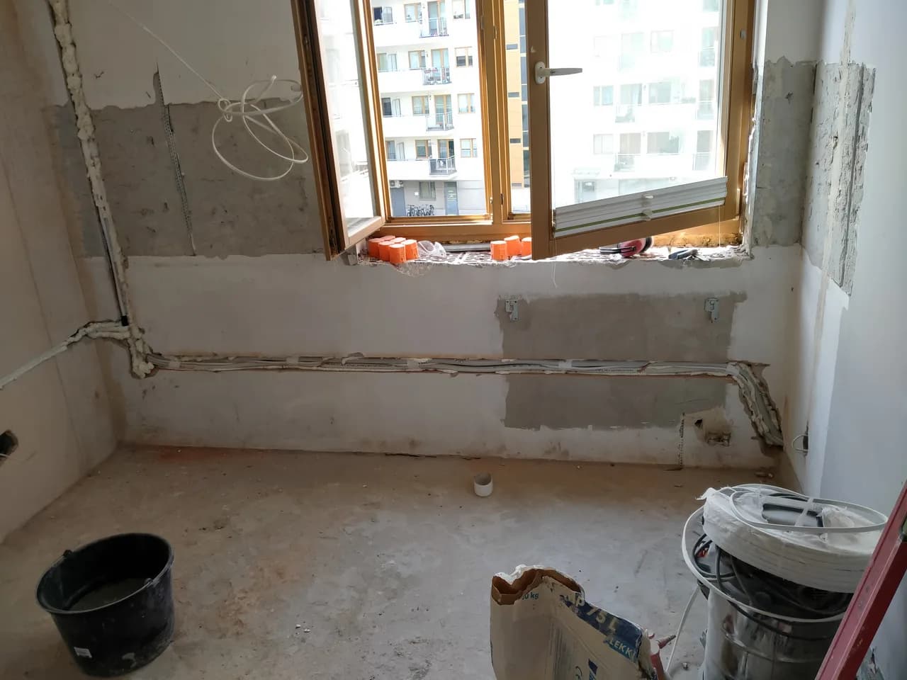 Instalacja w bruździe przy drewnianym oknie w mieszkaniu w trakcie remontu