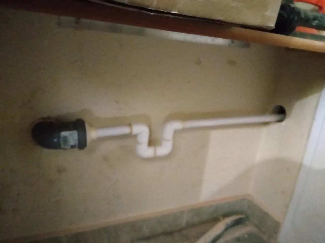 Biały syfon odprowadzenia skroplin klimatyzacji podłączony do instalacji sanitarnej