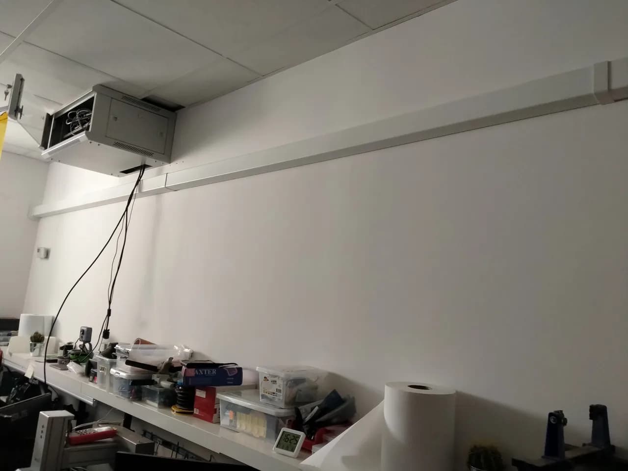 Pomieszczenie zaplecza z regałami i poprowadzoną pod sufitem instalacją klimatyzacji
