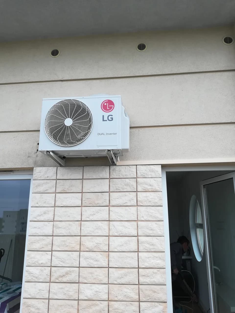 Taras apartamentu z jednostką zewnętrzną klimatyzacji zamontowaną wysoko na elewacji