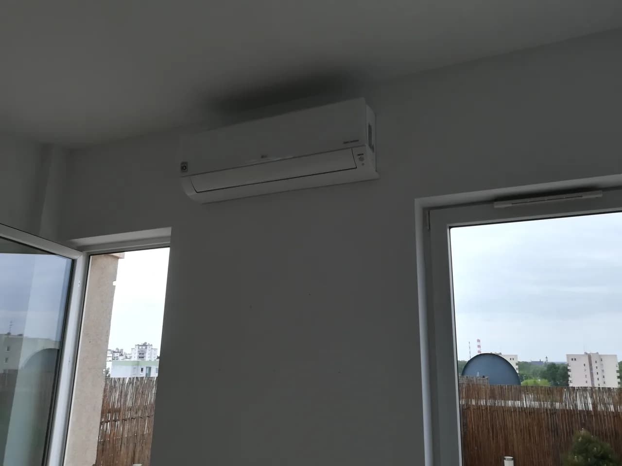 Trzeci pokój apartamentu z klimatyzatorem ściennym i wyjściem na taras z matą trzcinową