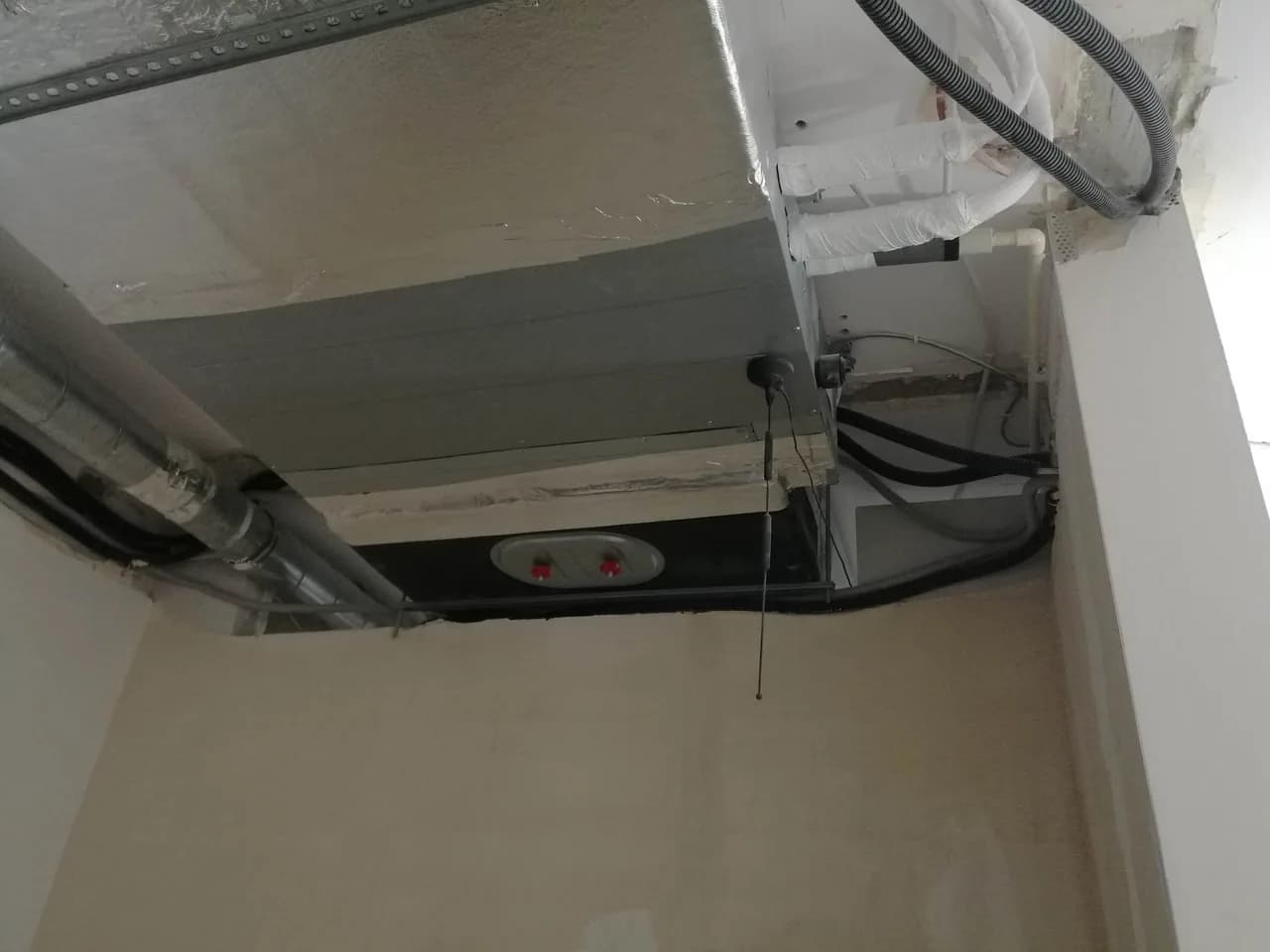 Kanał wentylacyjny przechodzący pod stropem nad ścianką działową w biurze w budowie